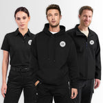 Three models wearing black custom-branded apparel: a short-sleeve polo shirt, a pullover hoodie, and a zip-front jacket, each with a circular white logo patch on the chest reading 'YOUR LOGO'.