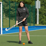 model wearing Premium Skort in black on the hockey pitch
