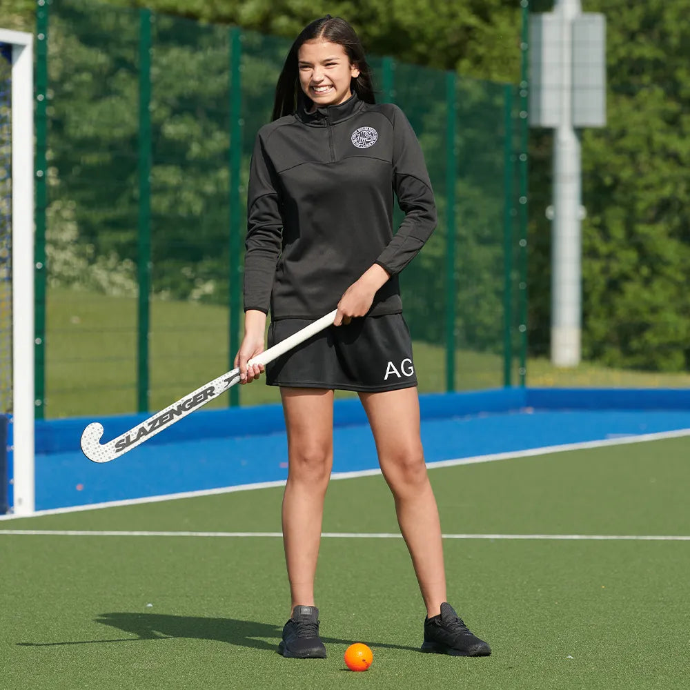 model wearing Premium Skort in black on the hockey pitch