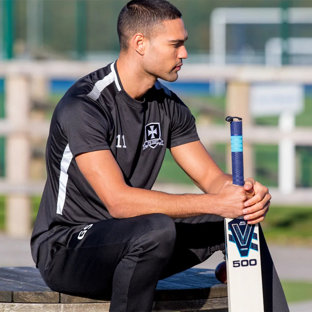 model wearing Edge Pro Training Tee with cricket bat
