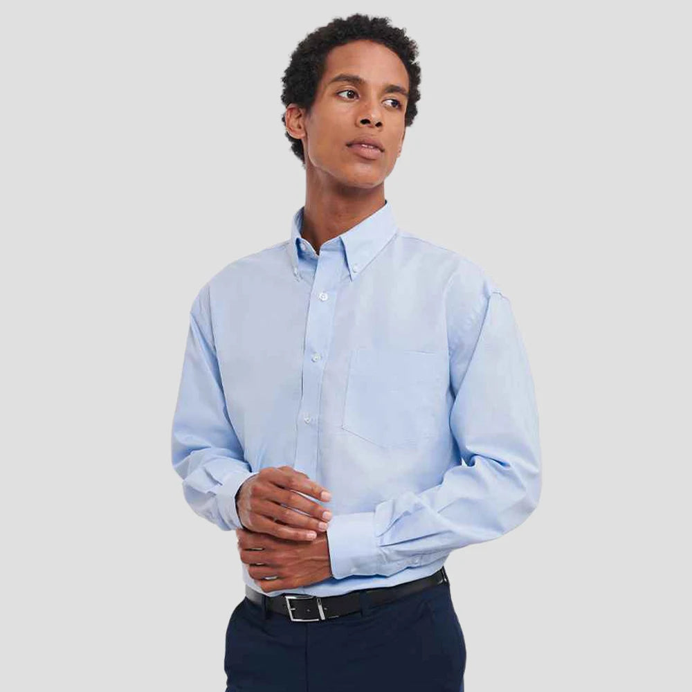 Model wearing the Russell Collection Long Sleeve Easy Care Oxford Shirt 932M in Oxford Blue
