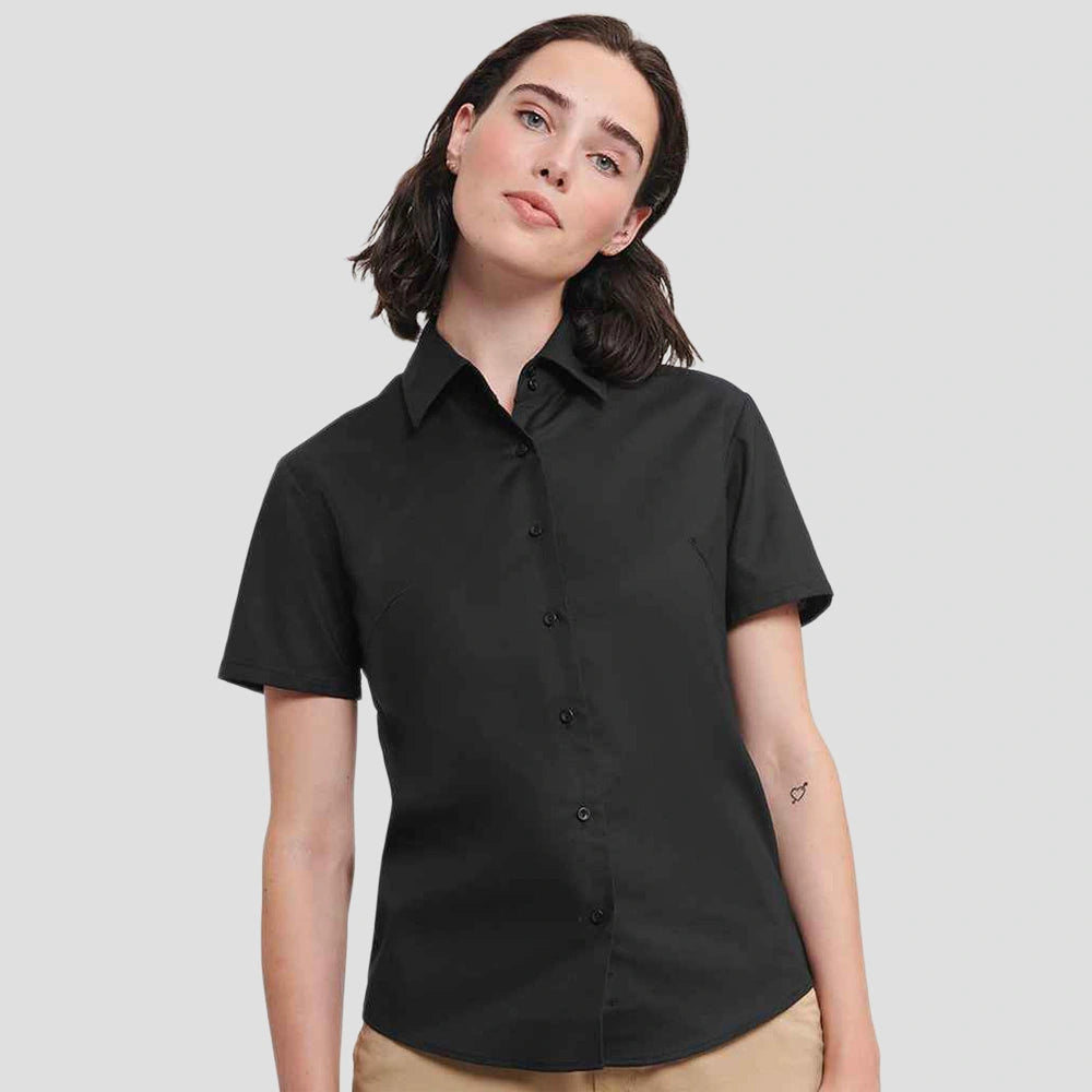 Model wearing the Russell Collection Ladies Short Sleeve Easy Care Oxford Shirt 933F in Black