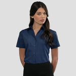 Model wearing the Russell Collection Ladies Short Sleeve Easy Care Poplin Shirt 935F in French Navy