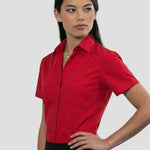 Model wearing the Russell Collection Ladies Short Sleeve Easy Care Poplin Shirt 935F in Red