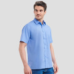 Model wearing the Russell Collection Short Sleeve Easy Care Poplin Shirt 935M in Corporate Blue
