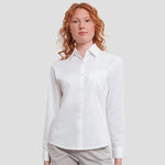 Model wearing the Russell Collection Ladies Long Sleeve Easy Care Cotton Poplin Shirt 936F in White