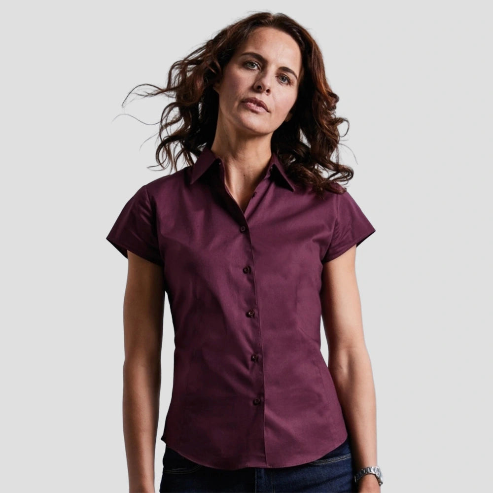 Model wearing the Russell Collection Ladies Short Sleeve Easy Care Fitted Shirt 947F in Port