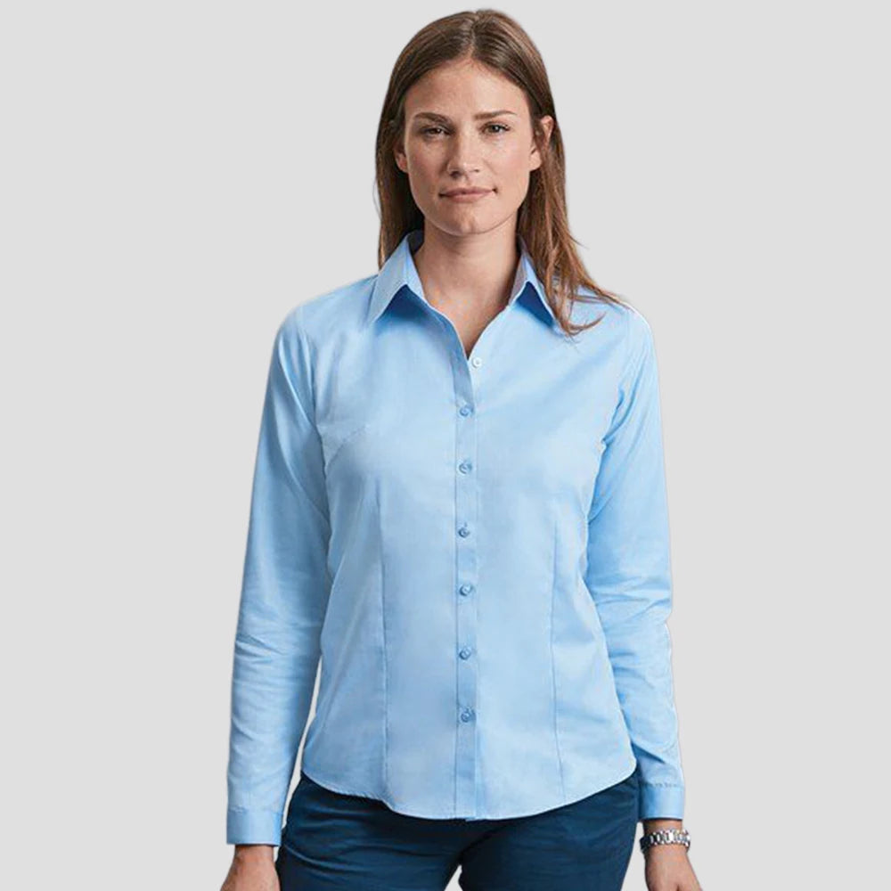 Model wearing the Russell Collection Ladies Long Sleeve Herringbone Shirt in Light Blue