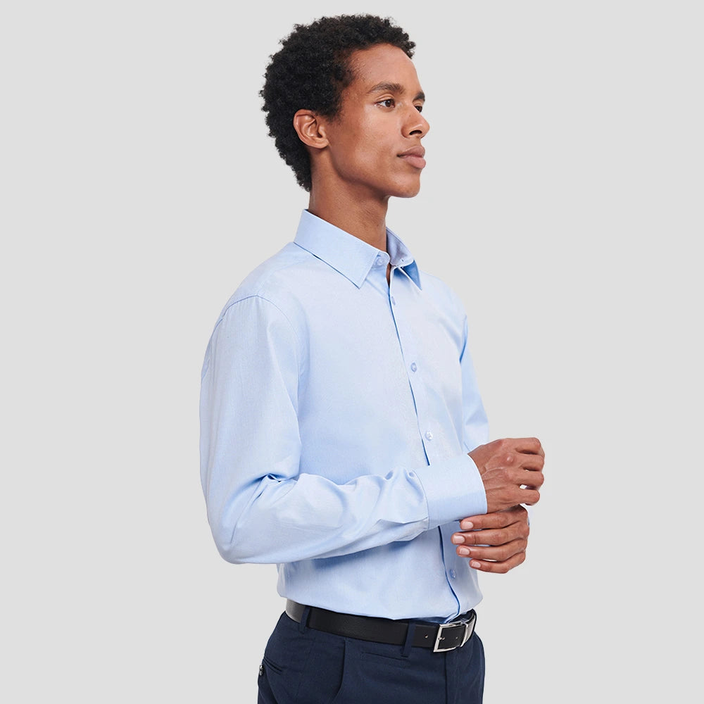Side angle of Model wearing the Russell Collection Long Sleeve Herringbone Shirt 962M in Light Blue