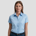 Model wearing the Russell Collection Ladies Short Sleeve Herringbone Shirt 963F in light blue