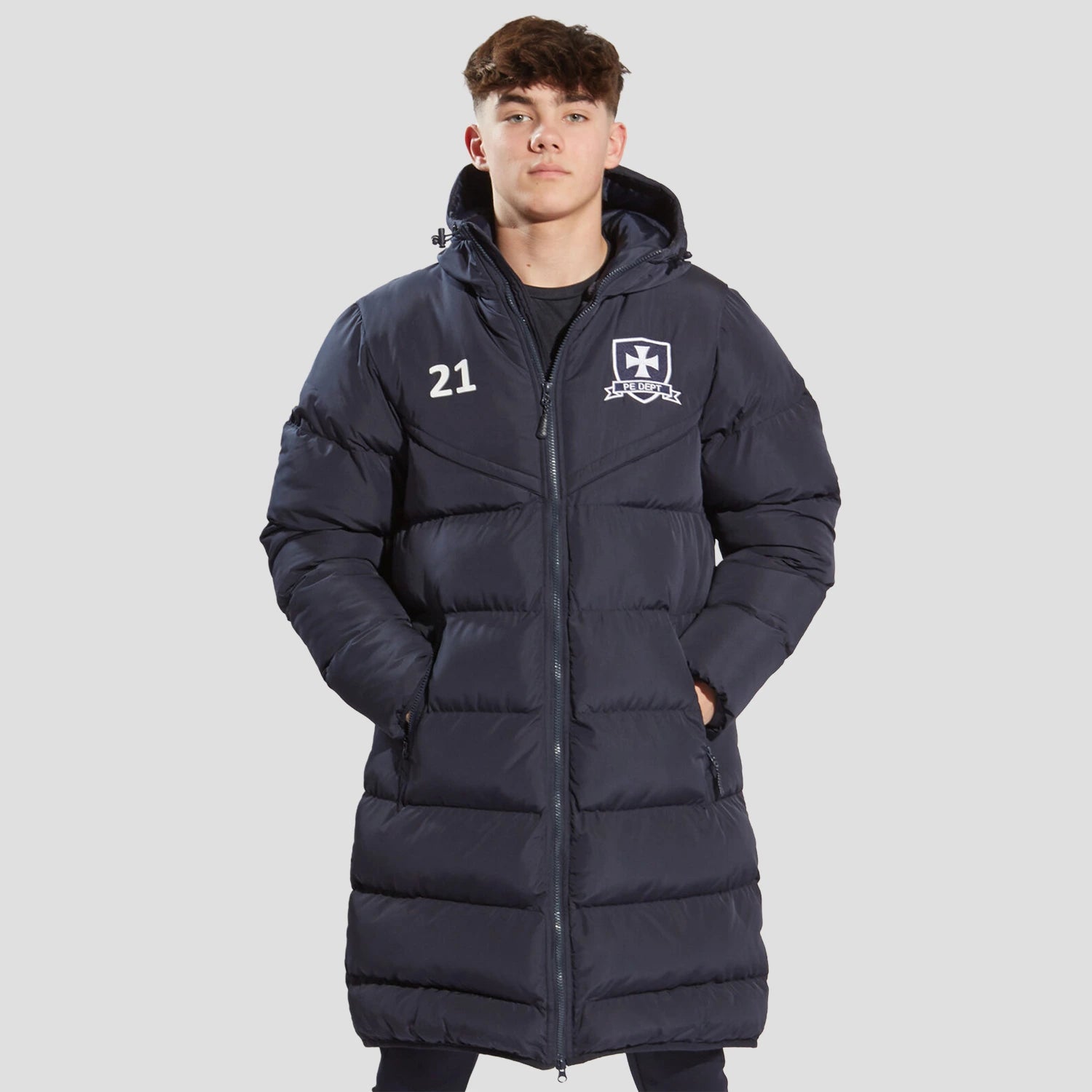Model wearing the the Chadwick Teamwear Youth Chevron Puffer Coat in Navy.