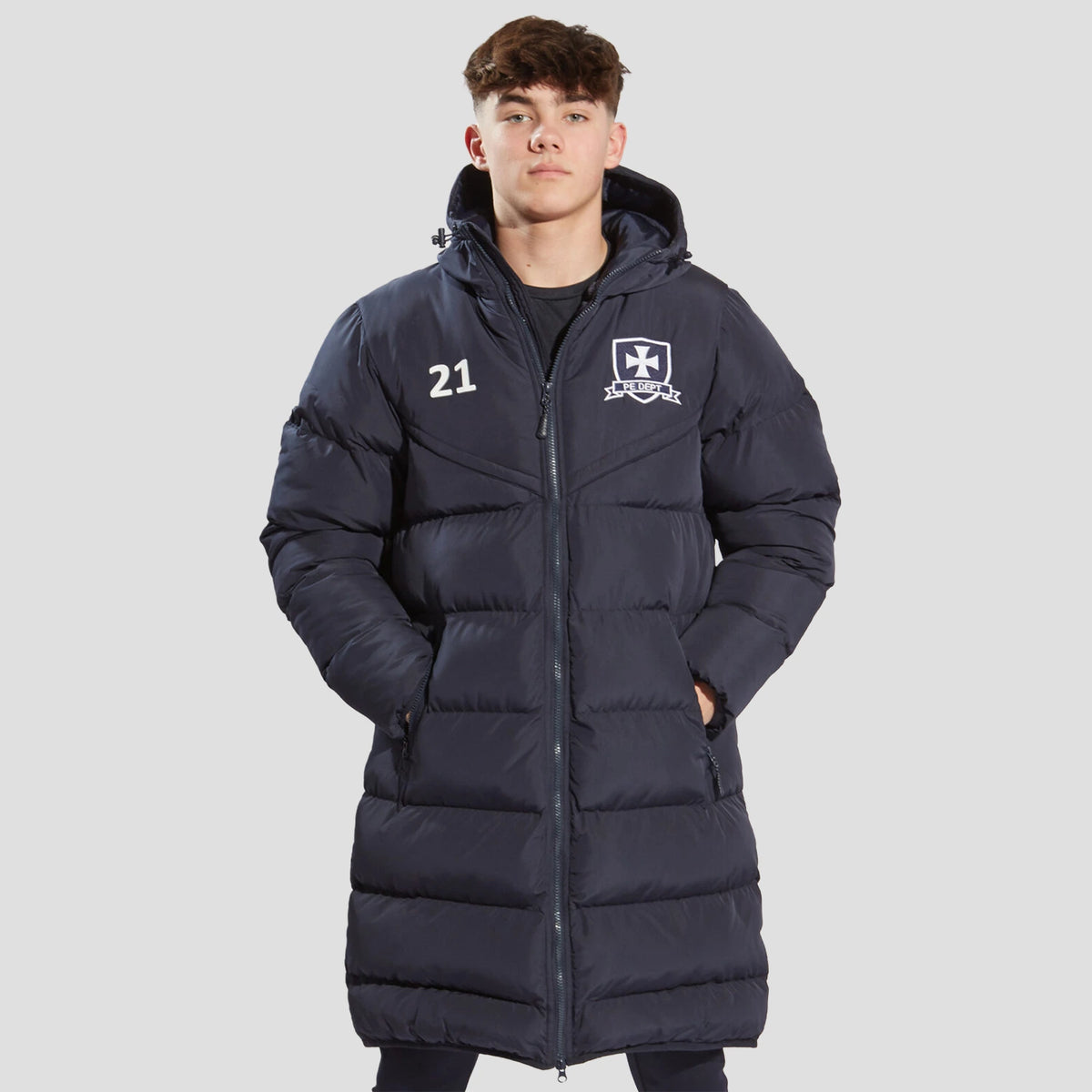 Model wearing the the Chadwick Teamwear Youth Chevron Puffer Coat in Navy.