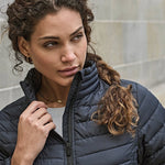 close up lifestyle image of model wearing Tee Jays Ladies Zepelin Padded Jacket