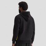 Person wearing a black Uneek Two Tone Hooded Sweatshirt UC517