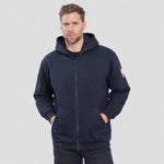 A man wearing a navy blue Portwest - FR Zip Front Hooded Sweatshirt