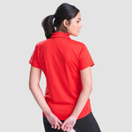 Model wearing the AWDis Ladies Cool Polo Shirt JC0045 in Fire Red