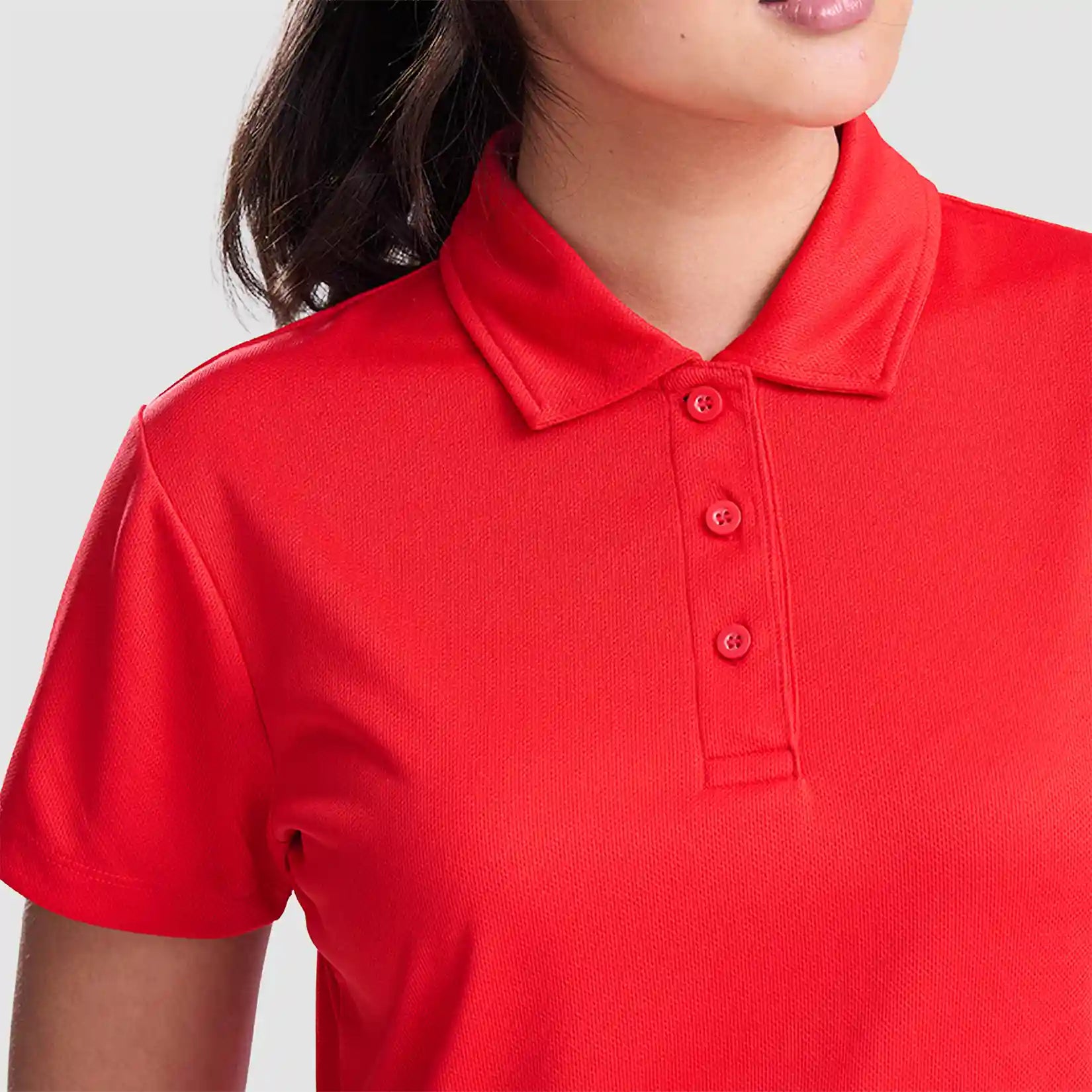 Model wearing the AWDis Ladies Cool Polo Shirt JC0045 in Fire Red
