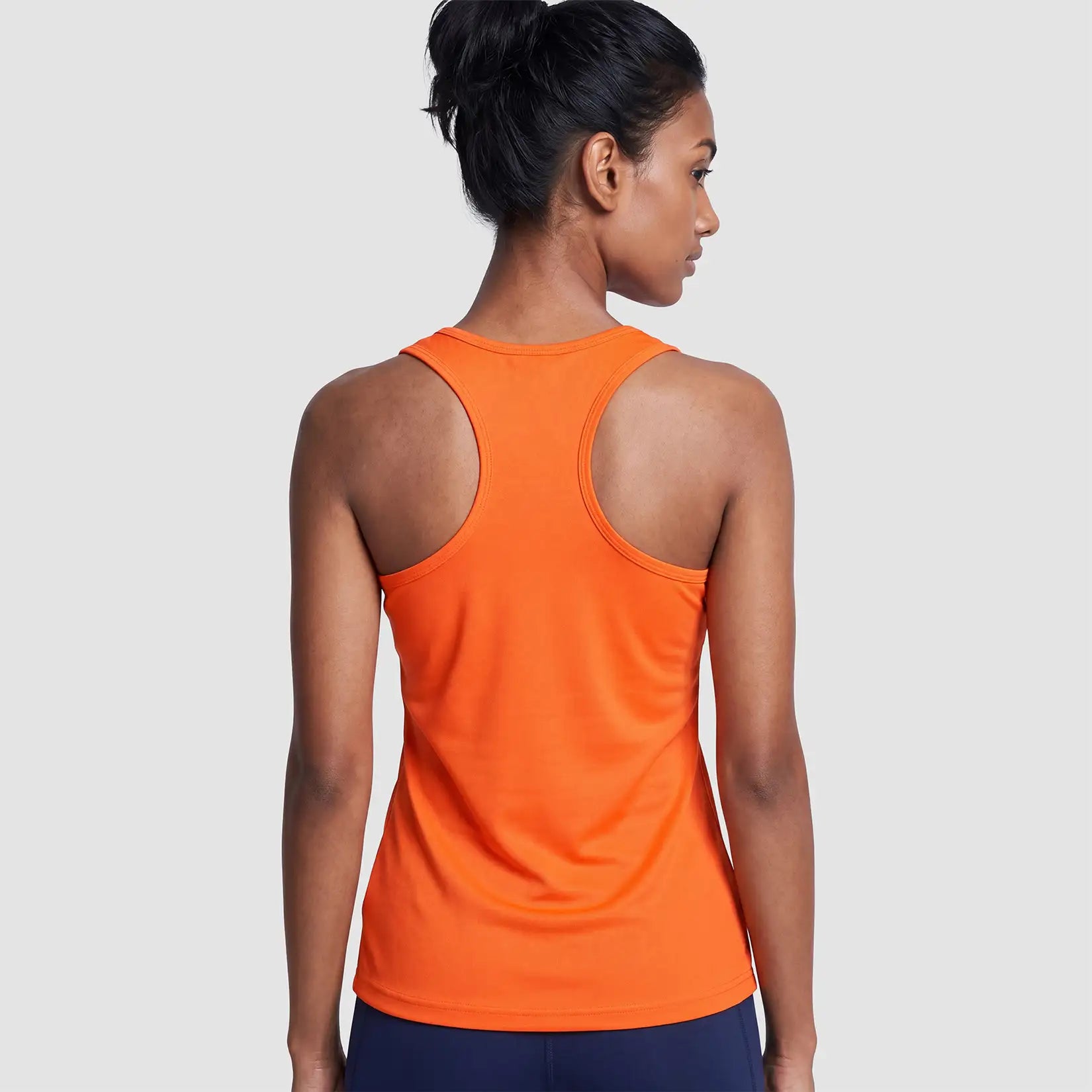Rear view of model wearing the Cheshire Stars Netball Club Ladies Vest (Orange) - Adult