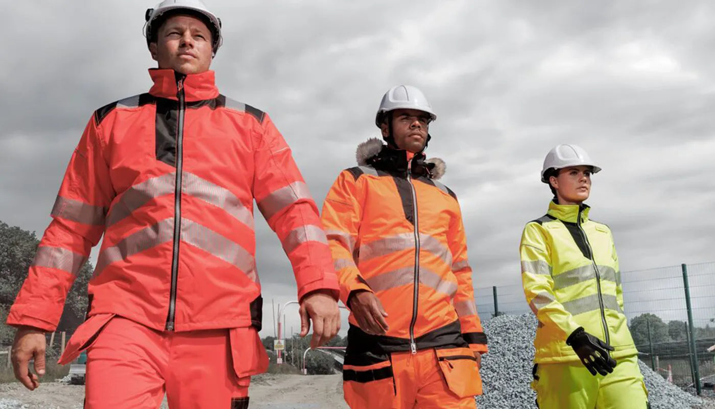 Three individuals wearing high-visibility hi vis safety jackets and hard hats