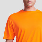 Close-up shot of Model wearing the JC020 AWDis Cool Smooth T-Shirt in Electric Orange