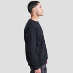 Side view of Model wearing the JH030 AWDis Sweatshirt in Deep Black