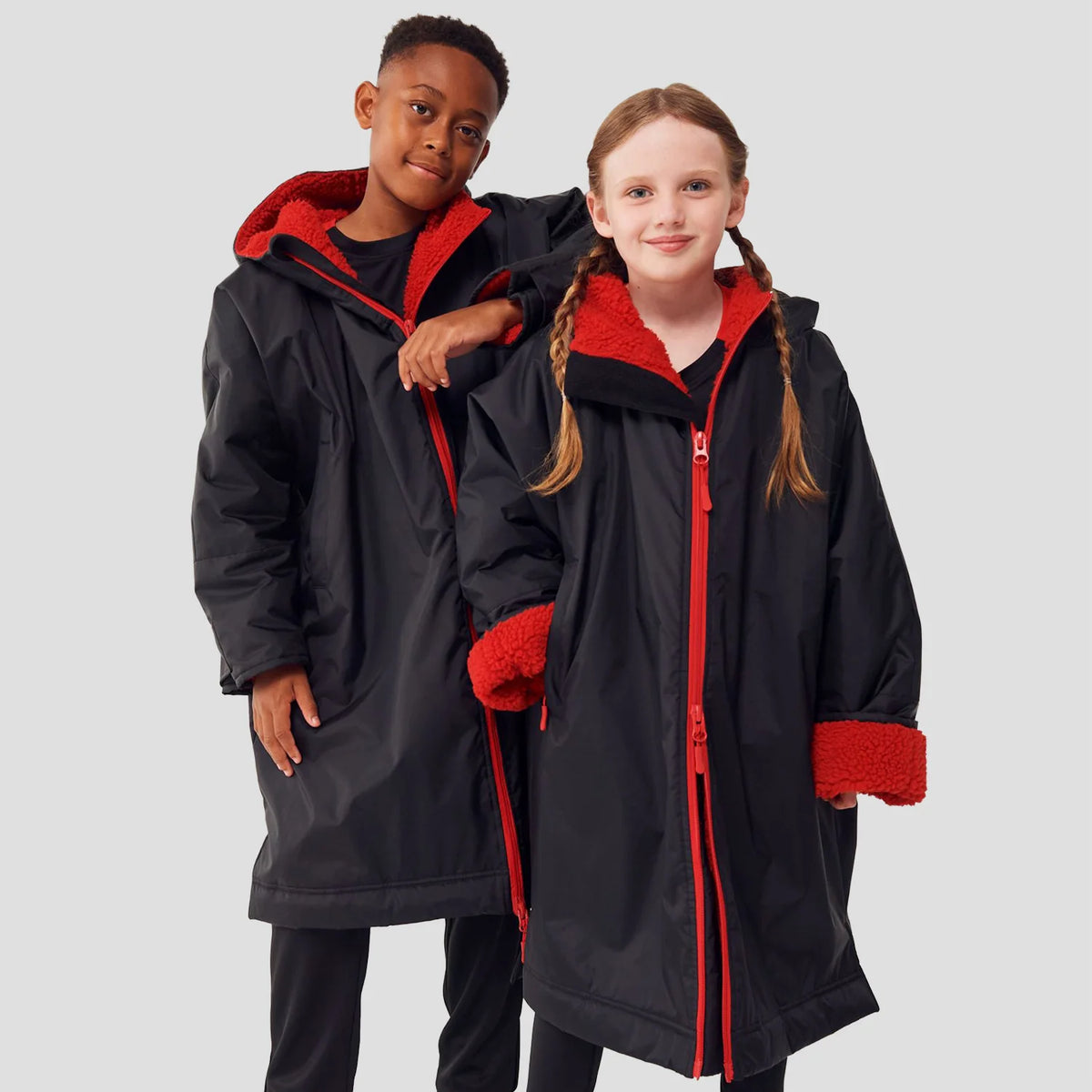 Two models wearing the Finden Hales Kids All-Weather Robe in black/red.