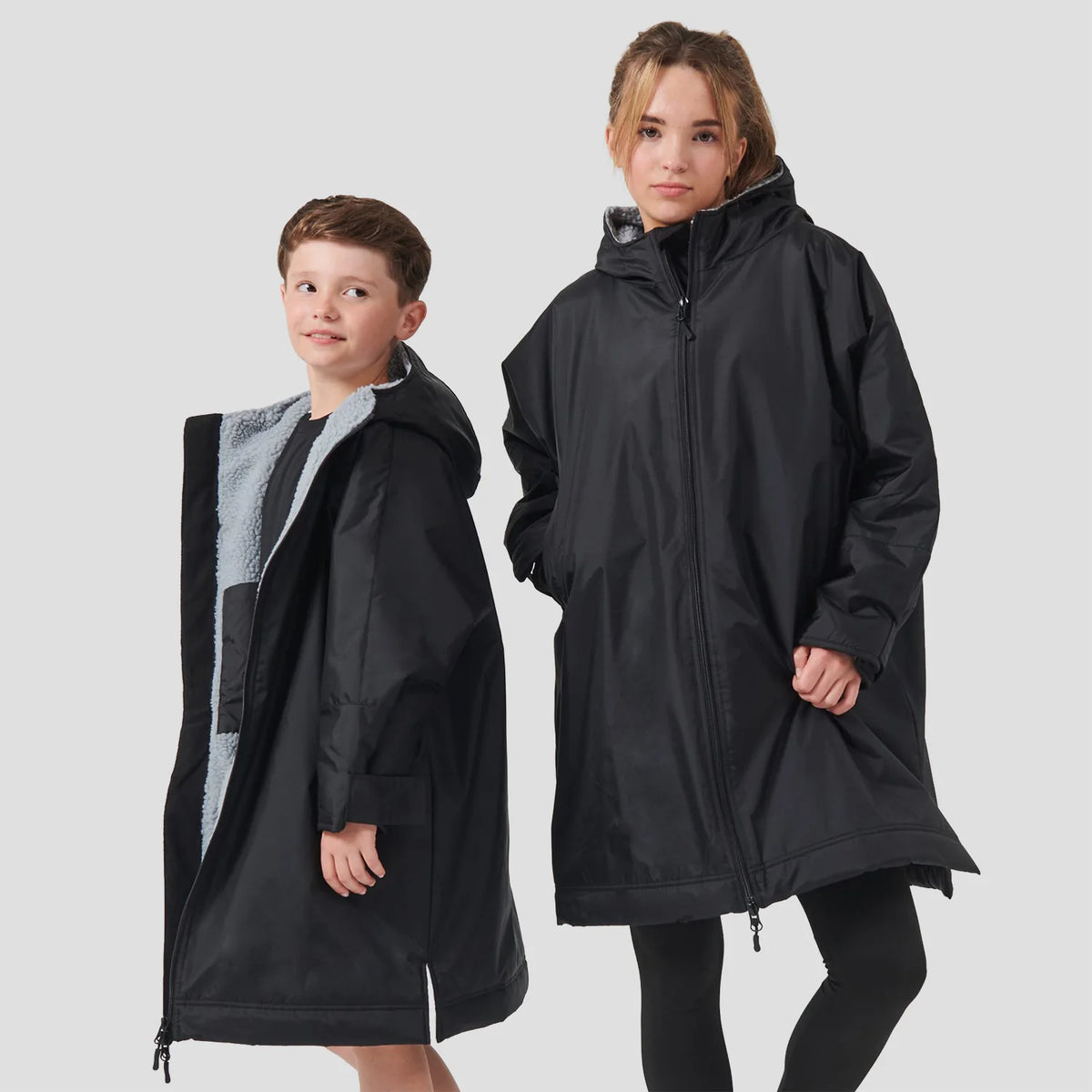 Two models wearing the Finden Hales Kids All-Weather Robe in black.