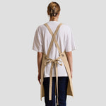 Rear view of model wearing the Premier Cross Back Barista Bib Apron PR129.