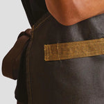 Side view of model wearing the Premier Division Bib Apron PR136.
