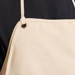 Close-up of model wearing the Premier 'Artisan's Choice' Double Pocket Canvas Apron PR181 in Natural.