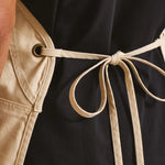 Rear close-up of model wearing the Premier 'Artisan's Choice' Double Pocket Canvas Apron PR181 in Natural.