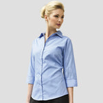 Model wearing the Premier Ladies 3/4 Sleeve Poplin Blouse in Mid Blue.