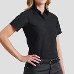 Model wearing the Premier Ladies Supreme Short Sleeve Poplin Shirt in Black.