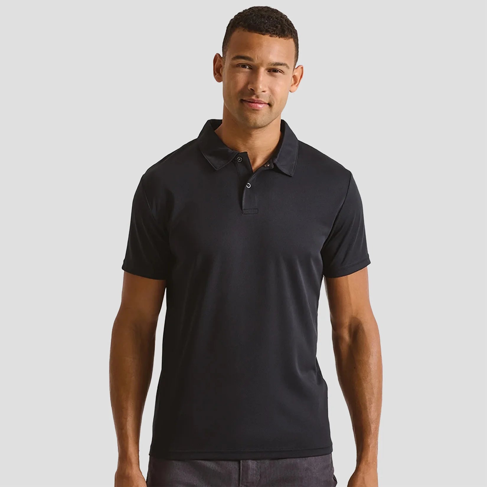 Male model wearing the Premier Coolchecker® Stud Piqué Polo Shirt PR612 in Black
