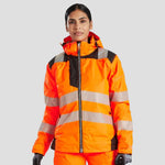Model wearing the PW3 Hi-Vis Women's Winter Jacket in Orange.
