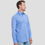 Side view of Model wearing the Russell Collection Long Sleeve Tailored Poplin Shirt 924M in Corporate Blue