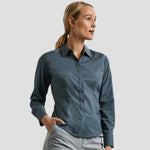 Model wearing the Russell Collection Ladies Long Sleeve Fitted Poplin Shirt 924F in Convoy Grey
