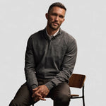 sitting man weaing Tee Jays Half Zip Sweater