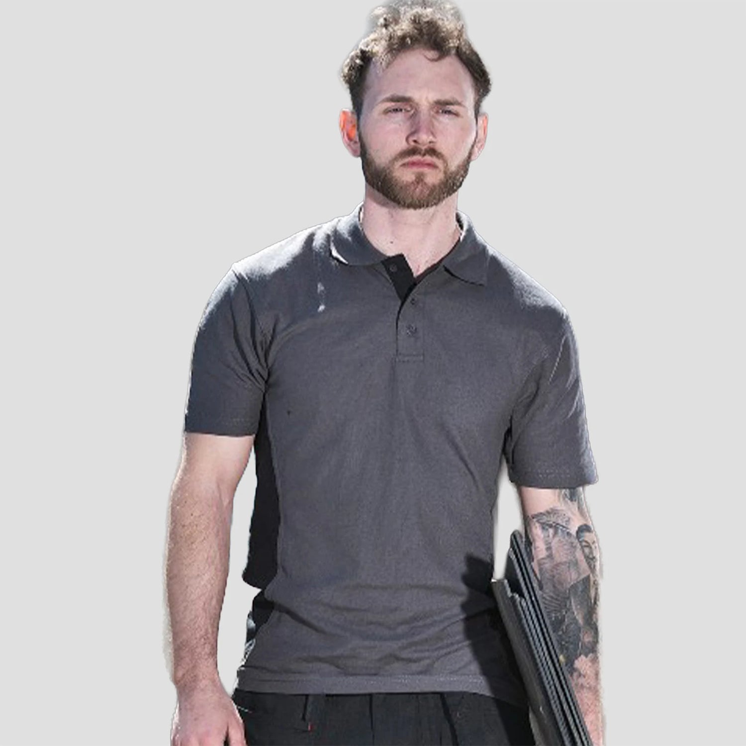 Model wearing the TuffStuff Pro Work Polo Shirt in Charcoal / Black
