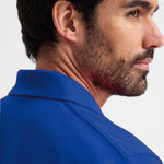 close up of model wearing Active Polo Shirt - Corporate Colours UC105 in royal