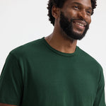 close up front view of model wearing Uneek Olympic T-shirt UC320 bottle