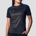 Model wearing the Surridge Sport Women's Volt T-Shirt in Black with Royal Diagonal Trim.