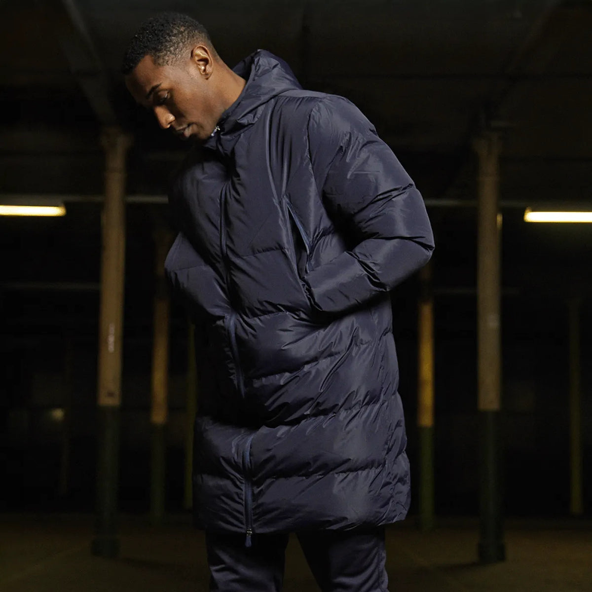 Side view of model wearing the Stuart Surridge Active Long Padded Coat WL005 in Navy.